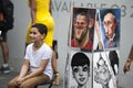 Street artist paints a portrait of a boy