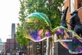 Street artist performing blowing huge soap bubbles