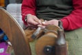 A street artist sewing manufacturing with traditional spinning wheel