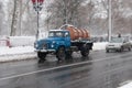 Street in bad weather in winter. Cars are driving on a slippery road. There is a snowstorm.