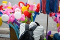 A street balloon vendor sleeps on the street