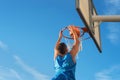 Street basketball athlete performing slam dunk on the court