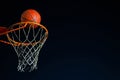 Street basketball ball falling into the hoop at night. Urban youth game. Close up of orange ball above the hoop net. Concept of Royalty Free Stock Photo