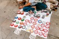 Street beggar sales some handmade art for money