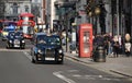 Street with black cabs, a red bus and a red phone box on the Strand