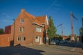 Street with brick houses, trees and cranes with blue sunset sky in Tielt.