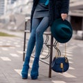 Street, bright style. A young girl in a blue fur coat and a hat with a handbag in heels. Details