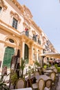 Street with building and umbrellas with cafe tables at restaurants in Valletta, Malta Royalty Free Stock Photo