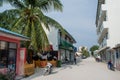 Street with buildings, bikes and people at the tropical island Maamigili Royalty Free Stock Photo