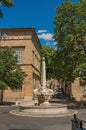 Street with buildings and fountain, sunny afternoon in Aix-en-Provence.