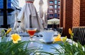 Street cafe cup of coffee and glass of carrots  juice on table top summer flowers and plant leaves urban  modern design Royalty Free Stock Photo