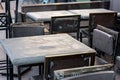 Street cafe with a gray painted iron table and black iron chairs.