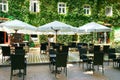 Street cafe interior in city park, old home with wall in green leaves, summer season, bright sunny day Royalty Free Stock Photo