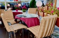 Street Cafe on table cup of coffee and pink flowers pink coral tablecloth on the table and yellow chair cloth morning breakfast