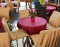 Street Cafe on table cup of coffee and pink flowers pink coral tablecloth on the table and yellow chair cloth morning breakfast