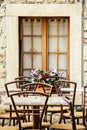 Street cafe, tables and chairs by the window with flowers. Italy, outdoor trattoria Royalty Free Stock Photo