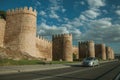 Street with car in front towers on the wall around Avila