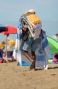 street carpet vendor walks on the sunny beach Royalty Free Stock Photo