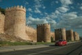 Street with cars in front towers on the wall around Avila