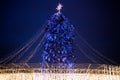 Street city Christmas tree at night. The garlands are burning. Holiday decorations and toys. Garland of lights.