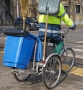 Street cleaner man on bicycle with garbage can Royalty Free Stock Photo