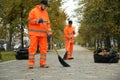 Street cleaners sweeping fallen leaves outdoors on autumn day Royalty Free Stock Photo