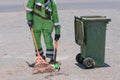 Street cleaning, male municipal worker collecting street rubbish to dumpster. Labor law, labor rights for migrants, refugee