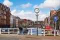 Street clock, bridge, bike, traditional houses, canal in Leiden, Netherlands