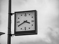 Street clock with a traditional dial and hands arrows for hours and minutes. An rectangular boxed analog clock on a city lighting Royalty Free Stock Photo