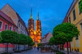 Street with cobblestone road, green trees, colorful buildings, Cathedral of St. John the Baptist church Royalty Free Stock Photo
