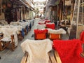 Street coffee shop tables and chairs with warm cloth in Kalari street Ioannina city