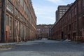 Street through a complex of derelict industrial buildings, daylight