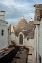 A street corner with a typical white cottage in alberobello with nice pointed roofs