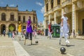 A street dance group in Havana, wearing colorful costumes, is showing their artistic tricks on stilts on the famous Plaza Vieja