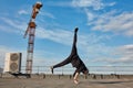 Street dancer hipster guy makes back flip with arm support on the roof outdoor. Royalty Free Stock Photo