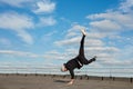 Street dancer hipster guy makes back flip with arm support on the roof outdoor. Royalty Free Stock Photo