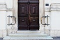 Street detail with old stained brown entrance gate. stone exterior facade Royalty Free Stock Photo