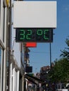 Street digital thermometer displaying a temperature of 32 degrees celsius. Heat wave concept.