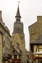 Street of Dinan with vintage architecture and clock tower of old church in Dinan, France Royalty Free Stock Photo