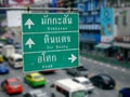 Street Directional Labels with Thai and English Texts and Arrows to Other Places in Bangkok Royalty Free Stock Photo