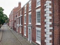 Street of elegant large brick 19th century houses in chester england with cobblestone pavement and road