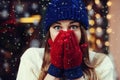 Street emotional portrait of young beautiful woman looking surprised and covering her mouth. Lady wearing stylish