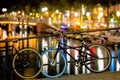 Street in the evening - bike and street lights, bridge and canal with reflection in the water. Romantic night scene of Amsterdam. Royalty Free Stock Photo