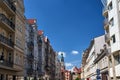 Street with facades of historic tenement houses and the tower of the town hall