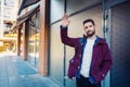 Street fashion model tourist man outdoor. Man wearing black bag and purple jacket, autumn. Royalty Free Stock Photo