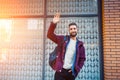 Street fashion model tourist man outdoor. Man wearing black bag and purple jacket, autumn. Royalty Free Stock Photo