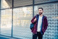 Street fashion model tourist man outdoor. Man wearing black bag and purple jacket, autumn. Royalty Free Stock Photo