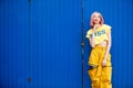 Street Fashion Woman with dying Pink Hair color wear yellow chic dress