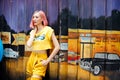 Street Fashion Woman with dying Pink Hair color wear yellow chic dress