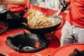 Street food chef cooking noodles and vegetables in a pan on fire at open kitchen. Fried noodles in a wok on the open fire. Asian Royalty Free Stock Photo